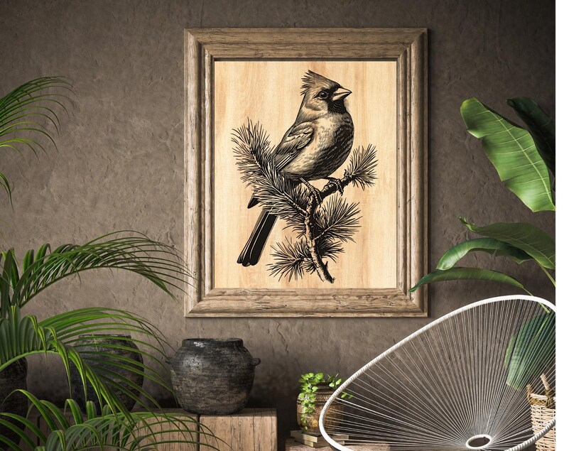 May include: A framed wood print of a black and white illustration of a cardinal perched on a branch of pine needles.