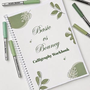 Könnte beinhalten: Ein spiralgebundenes Kalligrafie-Arbeitsbuch mit dem Titel Basic vs Bouncy Calligraphy Workbook, verziert mit salbeigrünen Blattillustrationen und vier salbeigrünen Acrylmarkern, die um das Notizbuch herum angeordnet sind.