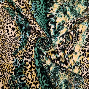 Puede incluir: Primer plano de una tela con estampado de leopardo en tonos negro, verde, amarillo y blanco.