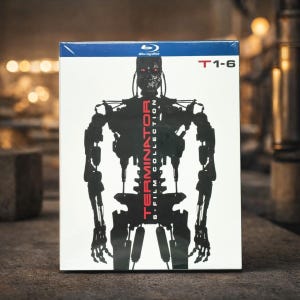 Puede incluir: Un set de caja de discos Blu-ray con la colección de 6 películas de Terminator. La portada muestra una silueta negra de un robot Terminator con la palabra "TERMINATOR" en rojo. La caja es blanca con la parte superior azul.