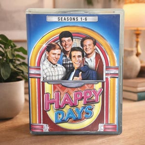 Può includere: Una tazza di ceramica bianca con manico nero e la scritta "But First, Coffee" in stile scritto a mano. La tazza è su una superficie bianca.