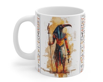 May include: White ceramic mug with a colorful illustration of the Egyptian god Anubis. The illustration features Anubis standing with a staff and an ankh in his hands. The background is a watercolor-style design with hieroglyphs.