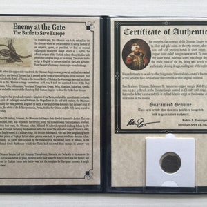 May include: A historical document with text and a coin. The document is in a black folder and includes a certificate of authenticity and information about the Ottoman Empire. The coin is in a protective sleeve.