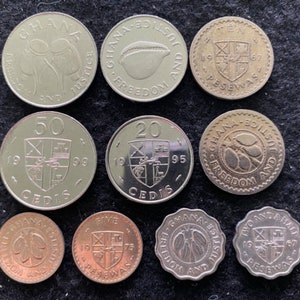 May include: A collection of nine silver and copper coins from Ghana. The coins feature various designs, including a cocoa pod, a coat of arms, and the words "Freedom and Justice".