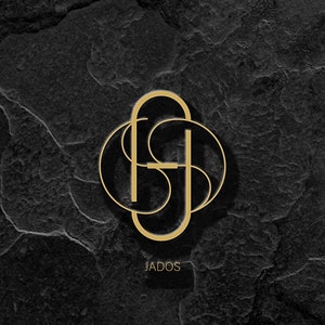 May include: A gold logo with the letters "JADOS" in a circle on a black textured background.