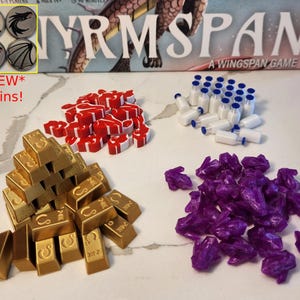 Puede incluir: Una colección de piezas de juego para el juego de mesa Wingspan. Las piezas incluyen monedas de oro, fichas de plástico rojo y blanco, cristales morados y pequeñas botellas blancas con tapas azules.