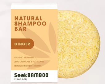 May include: A round, yellow shampoo bar labeled "Natural Shampoo Bar Ginger" with the text "Organic Ingredients, Zero Chemicals & Sulfate-Free, Replenish Nutrient - Fortify, Seek Bamboo, 91 g (3.2 oz)".