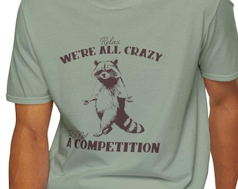 Camiseta con gráfico de mapache: Relájate, estamos todos locos - Camiseta unisex con colores cómodos