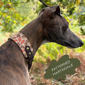 May include: A wide martingale dog collar featuring a beige fabric band with a repeating pattern of brown and orange oak leaves, secured with dark brown leather straps, brass rivets, and a metal D-ring, with the text PATTERNED MARTINGALE.