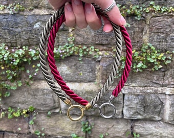 May include: Two rope necklaces, one red and one gray, with gold and silver ring clasps.