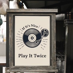 May include: A wooden sign with a white background and black text that reads "If It's Nice! Play It Twice". The sign features a black and white illustration of a record player with a record on it.