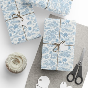 May include: Several wrapped gifts with blue and white toile paper featuring palm trees, cars, and buildings. Each package is tied with twine and a white tag. A ball of twine, scissors, and blank tags are also present.