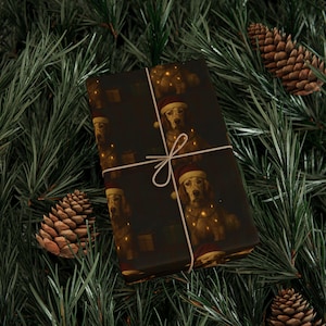 May include: Dark brown wrapping paper with a repeating pattern of a dog in a Santa hat and fairy lights. The wrapped gift is tied with white twine, set against a backdrop of pine needles and pine cones.