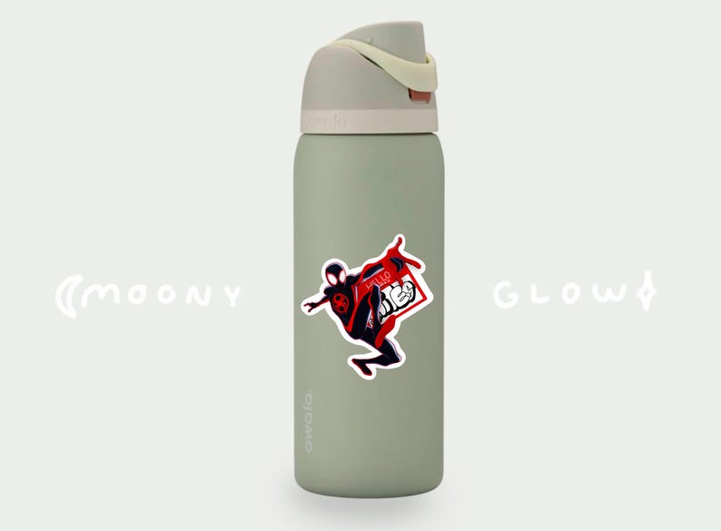 May include: A green reusable water bottle with a white lid and a sticker of a cartoon superhero in a red and black suit. The sticker says "Hello There" in red letters.