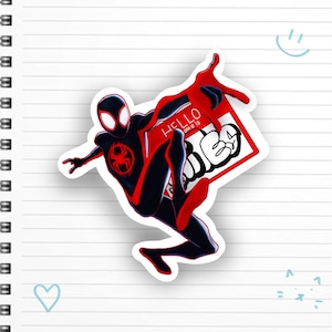 May include: A red and black Spider-Man character sticker with the text "Hello from the" and "other side" in white. The sticker is on a white lined notebook.