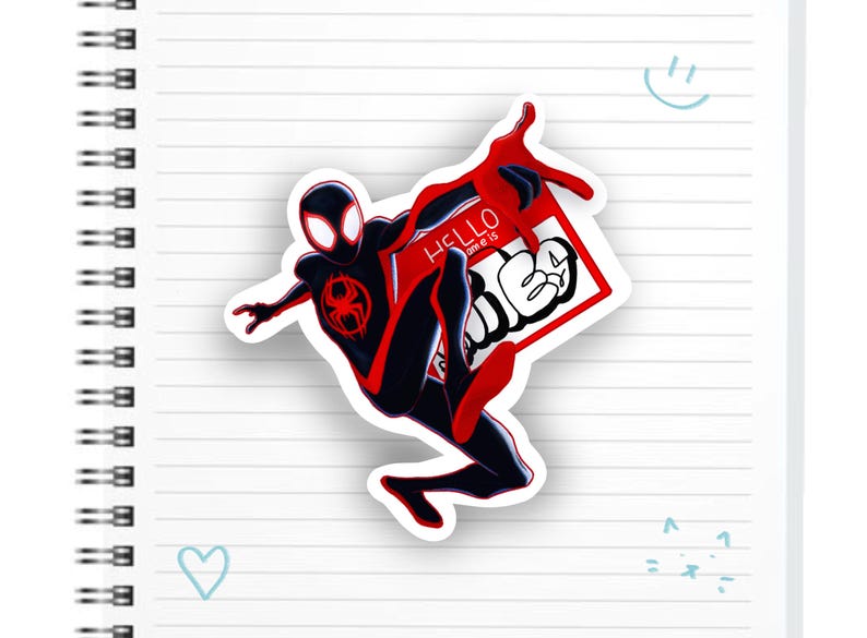 May include: A red and black Spider-Man character sticker with the text "Hello from the" and "other side" in white. The sticker is on a white lined notebook.