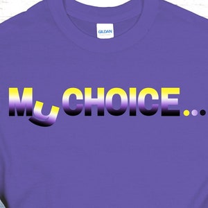 May include: A purple t-shirt with the text "My Choice..." in a gradient of yellow, white, black, and purple. The shirt is paired with blue jeans, yellow flowers, and striped sandals.