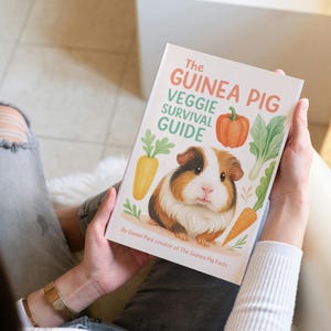Pu&ograve; includere: Un libro intitolato "The Guinea Pig Veggie Survival Guide" &egrave; tenuto da una persona. La copertina presenta un'illustrazione di porcellino d'India con verdure come carote, una zucca e lattuga. L'autore &egrave; Daniel Par&eacute;, creatore di The Guinea Pig Facts.