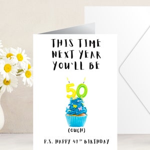 May include: A birthday card with a blue cupcake with green and yellow candles that say "50". The card says "This time next year you'll be 50 (ouch) P.S. Happy 49th Birthday"