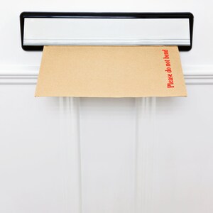 May include: A brown envelope with the words "Please do not bend" printed in red on the right side is sticking out of a silver mailbox.