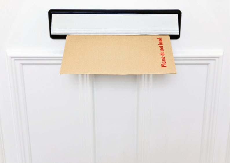 May include: A brown envelope with the words "Please do not bend" printed in red on the right side is sticking out of a silver mailbox.