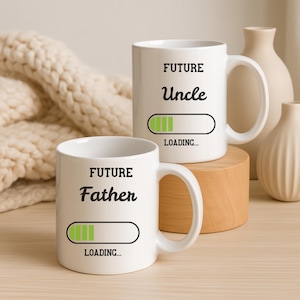 May include: A white ceramic mug with a black handle and the text "But First, Coffee" in a black, handwritten-style font. The mug is on a white surface.
