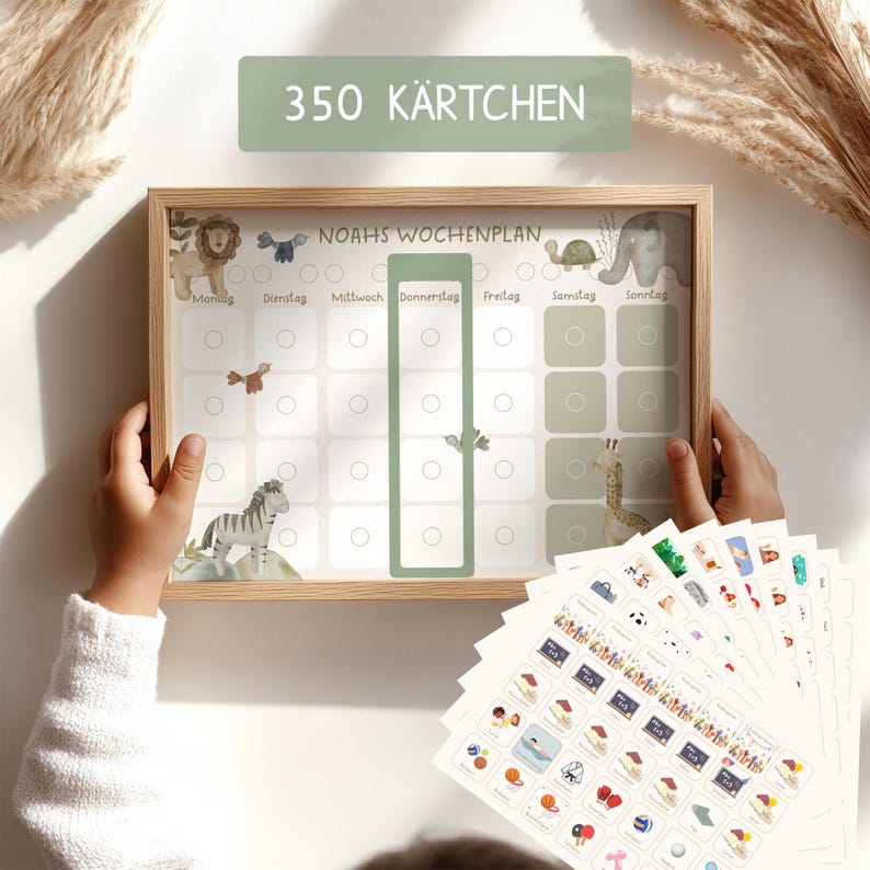 May include: A wooden framed weekly planner with a green background and a white grid. The planner has a title that says "Noah's Wochenplan" and has days of the week labeled in German. The planner has 350 stickers with various images of animals, activities, and objects.
