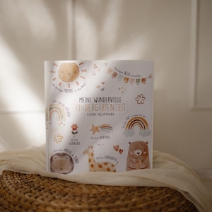 Könnte beinhalten: Ein weißes Buch mit einer Aquarell-Illustration einer Sonne, eines Regenbogens, einer Giraffe, eines Bären und einer Katze. Der Buchtitel lautet "Meine wundervolle Kindergartenzeit" und die Autorin ist "Liana Neumann".