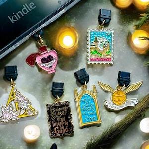May include: Five gold-colored Harry Potter themed book marks with different designs. The designs include a potion bottle, a Hogwarts castle, a Deathly Hallows symbol, a Hogwarts door, and a Golden Snitch.