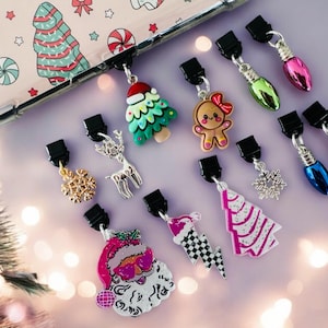以下が含まれることがあります： 携帯電話ケースやその他のアクセサリー用のクリスマスをテーマにしたチャーム10個セット。チャームには、ジンジャーブレッドマン、雪の結晶、クリスマスツリー、サンタクロース、電球、トナカイが含まれています。