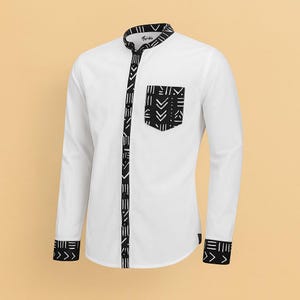 May include: A white long-sleeve shirt with a mandarin collar and black geometric pattern accents. The shirt features a black patterned pocket and trim along the placket and cuffs. The shirt is a stylish garment.
