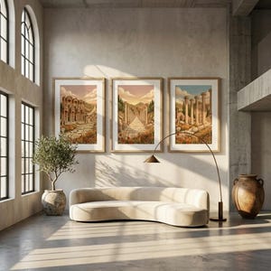 Puede incluir: Tres impresiones enmarcadas representan ruinas antiguas con columnas y caminos, sobre un cielo cálido al atardecer. La obra de arte se exhibe sobre un sofá beige curvado, con una lámpara de pie y un olivo en maceta.