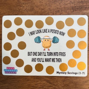 May include: A white card with gold scratch-off circles and text. The card features a cartoon potato lifting weights with the text "I MAY LOOK LIKE A POTATO NOW BUT ONE DAY I'LL TURN INTO FRIES AND YOU'LL WANT ME THEN."