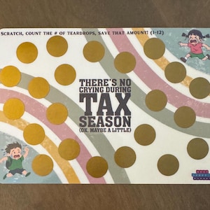 May include: A scratch-off card with a rainbow design and the text "THERE'S NO CRYING DURING TAX SEASON (OK. MAYBE A LITTLE)". The card features gold circles to scratch off and cartoon illustrations of crying children.