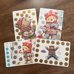 May include: Four rectangular cards with illustrations of bears wearing winter clothing. Each card has scratch-off circles in gold and silver. One card reads "SAVE $50". Another reads "Mystery (1-10)".