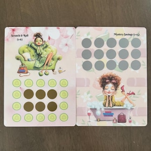 May include: Two pink cards with illustrations of women relaxing. One card says "Scratch & Roll" and features a woman on a green couch. The other card says "Mystery Savings" and shows a woman in a bathtub. Both cards have scratch-off circles.