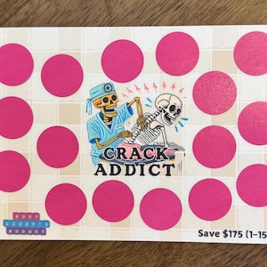 May include: A pink and white scratch-off game card with a skeleton in a blue shirt and a skeleton in a white shirt. The card says "Crack Addict" and "Save $175 (1-15)".