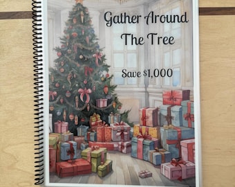 May include: A white spiral bound notebook with a Christmas-themed cover. The cover features a decorated Christmas tree with presents underneath. The text on the cover reads "Gather Around The Tree Save $1,000".