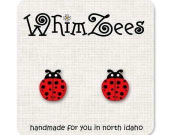 May include: A pair of ladybug earrings, handmade in North Idaho. The earrings are red with black spots and black antennae.