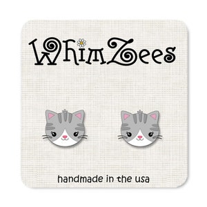 May include: A pair of gray cat face earrings with pink accents, set against a white background. The earrings are on a white card with the text "WhimZees" and "handmade in the usa".