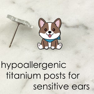 May include: Hypoallergenic titanium posts for sensitive ears.  A pair of cute cartoon corgi dog earrings with a blue bandana.