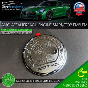May include: A silver AMG Affalterbach engine start/stop emblem. The emblem is 37mm in diameter and made of aluminum. The text "AMG Affalterbach" is visible on the emblem. The emblem is for Mercedes Benz.