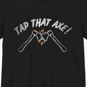 Puede incluir: Camiseta negra con un gráfico blanco de dos hachas cruzadas con el texto "TAP THAT AXE!" en blanco.