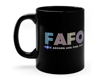 May include: Black coffee mug with a white graphic that says "FAFO - F*ck Around and Find Out" in a rainbow colour scheme.