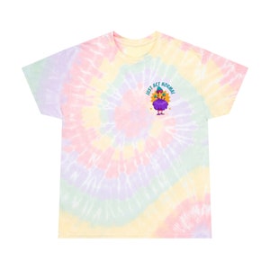 May include: A tie-dye t-shirt with a pastel color scheme. The shirt features a cartoon character with the text "Just Act Normal" above it.