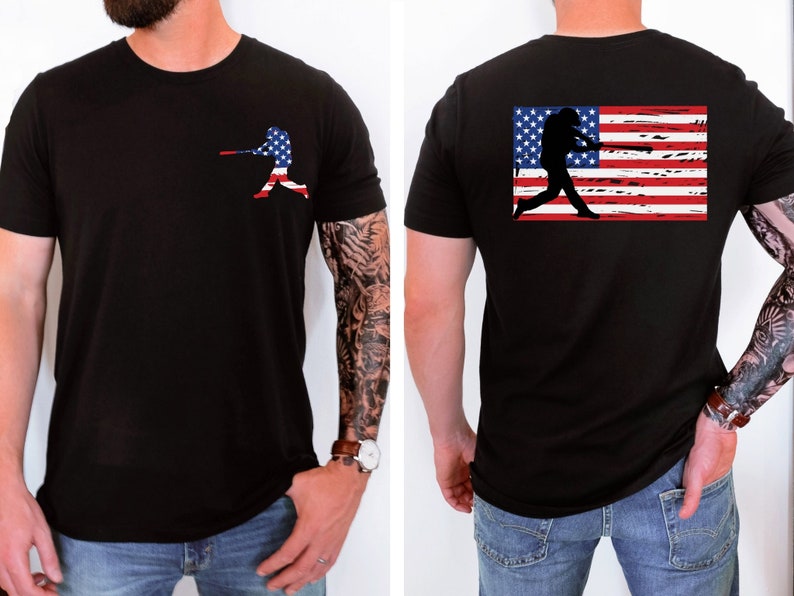 May include: Black t-shirt featuring a baseball player silhouette and an American flag on the back. The flag is distressed and has red, white, and blue stripes.