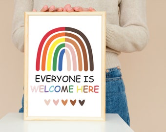 May include: A framed print with a rainbow arch made of different colored stripes, with the text "Everyone is Welcome Here" below the rainbow. There are five small hearts in a row below the text, each a different color.