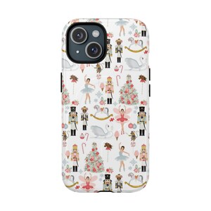 May include: A white phone case with a repeating pattern of ballet dancers, nutcrackers, toy soldiers, and Christmas trees. The design includes pink, blue, and gold accents, with a whimsical, festive theme.