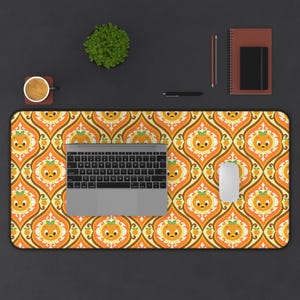 May include: A rectangular desk mat featuring a repeating retro-inspired pattern of orange cartoon characters with green leaves on their heads, set against a background of interlocking yellow, orange, and white curved shapes and lines.