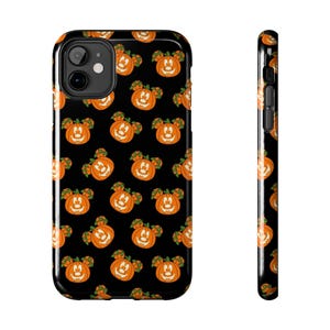 May include: Black phone case featuring a repeating pattern of orange jack-o'-lanterns with mouse ears. The pumpkins have smiling faces and green stems. The case is shown from the front and side.